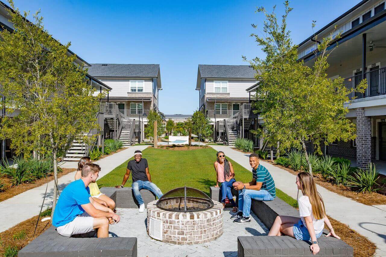 Wildwood Baton Rouge LSU Off-Campus Apartments with 6 Students hanging out at Courtyard Fire pit