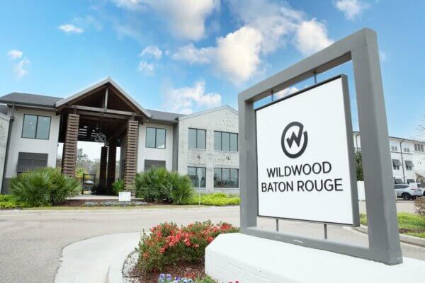 Wildwood Baton Rouge LSU Off-Campus Student Living Apartments: Exterior Entrance with Sign and Logo