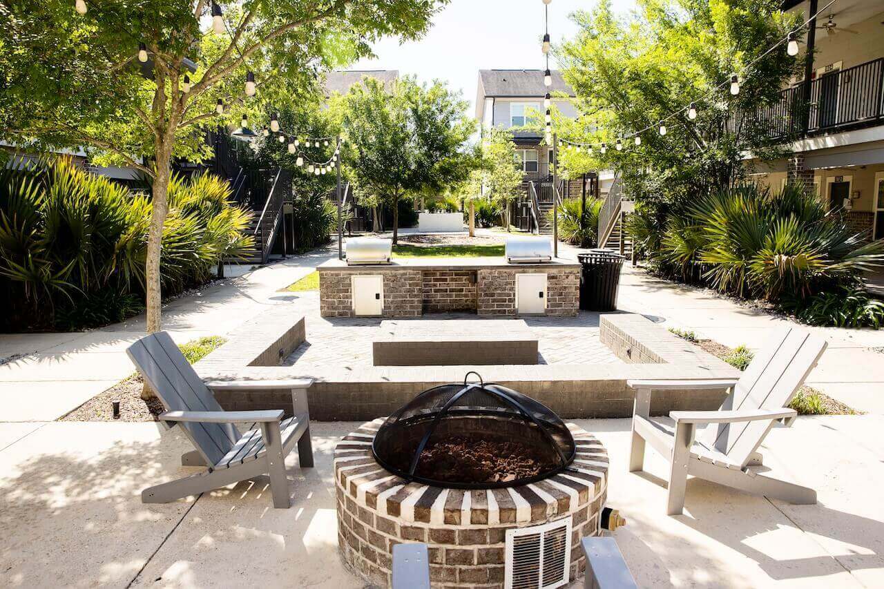 Wildwood Baton Rouge LSU Off-Campus Apartments Courtyard Fire Pit with String Lights and Lounge Chairs